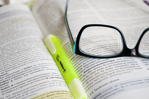 Image of a pen and a glass above a book